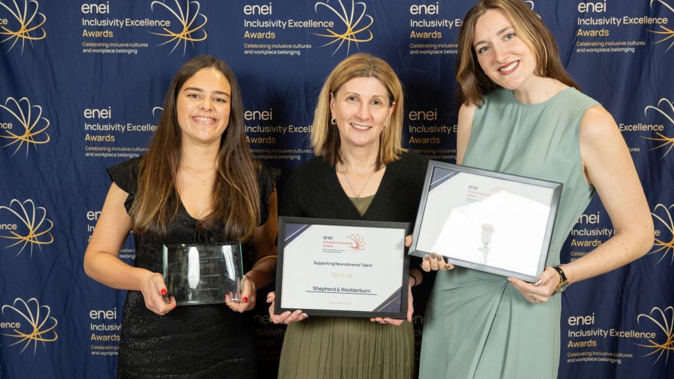 Award winners pose against the enei awards backdrop